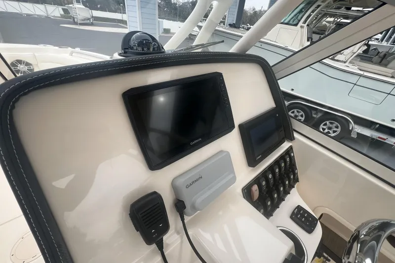 Slide: The Image of 2020 Grady-White Freedom 235 boat cockpit with steering wheel and control panel. - 12