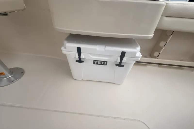 Slide: The Image of 2020 Grady-White Freedom 235 boat on trailer, parked near palm trees. - 5