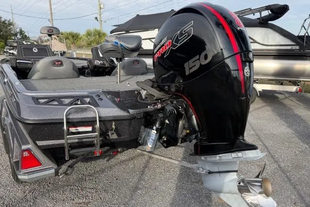 Slide: The Image of 2022 Ranger Z518 Tournament Elite boat with powerful 150 HP engine, parked outdoors. - 6