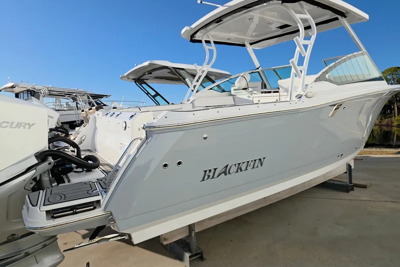Slide: The Image of 2021 Blackfin 272 DC boat with Mercury engines, docked on a sunny day. - 2