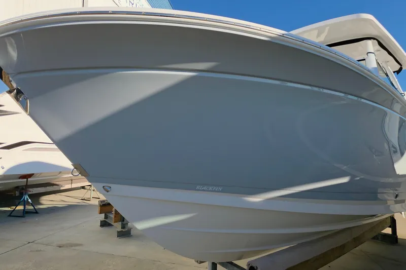 Slide: The Image of 2021 Blackfin 272 DC boat in a marina, showcasing sleek hull design. - 3
