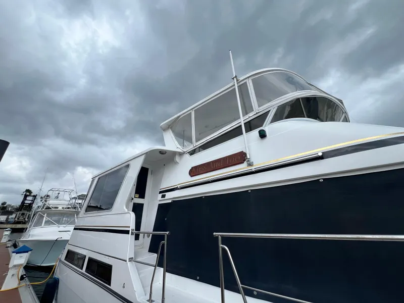 Slide: The Image of 1998 Hyatt 51 Aft Cabin Motor Yacht docked under cloudy skies. - 19