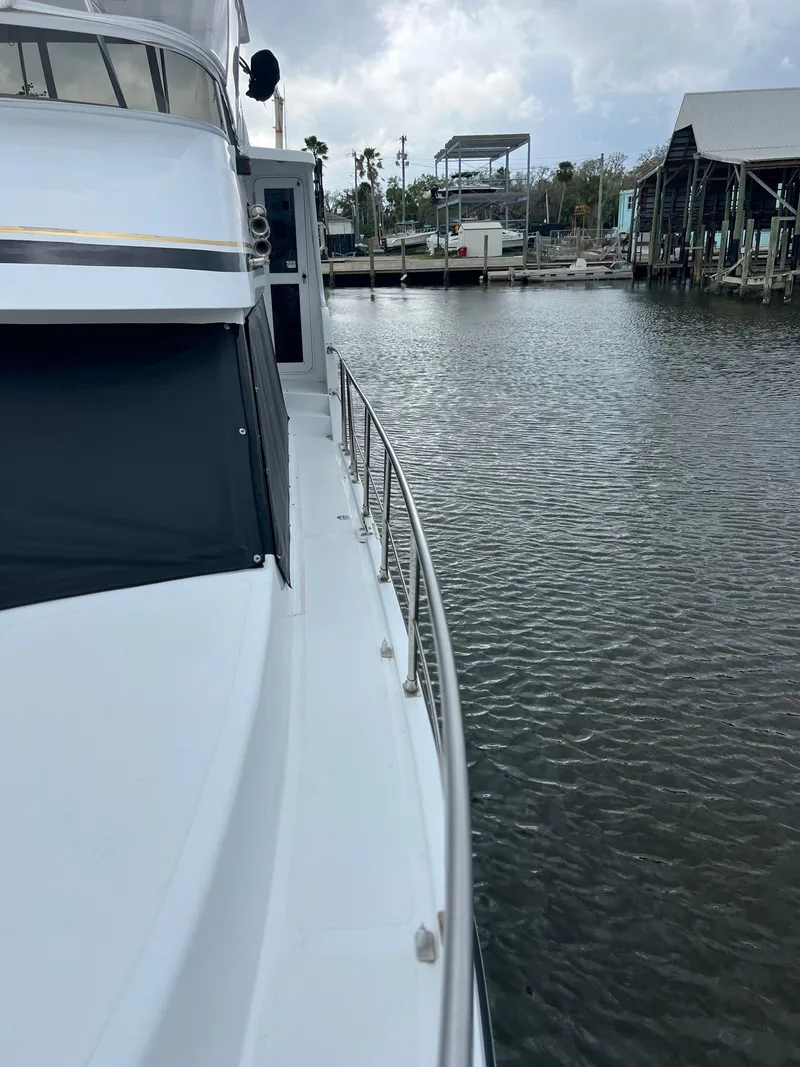 Slide: The Image of 1998 Hyatt 51 Aft Cabin Motor Yacht docked by calm waters. - 21