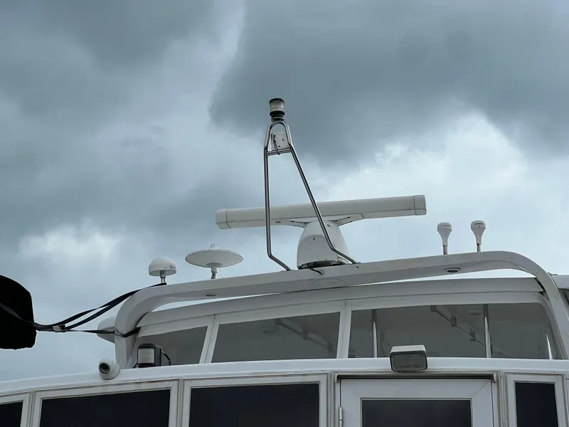 Slide: The Image of 1998 Hyatt 51 Aft Cabin Motor Yacht with radar, under cloudy skies. - 23