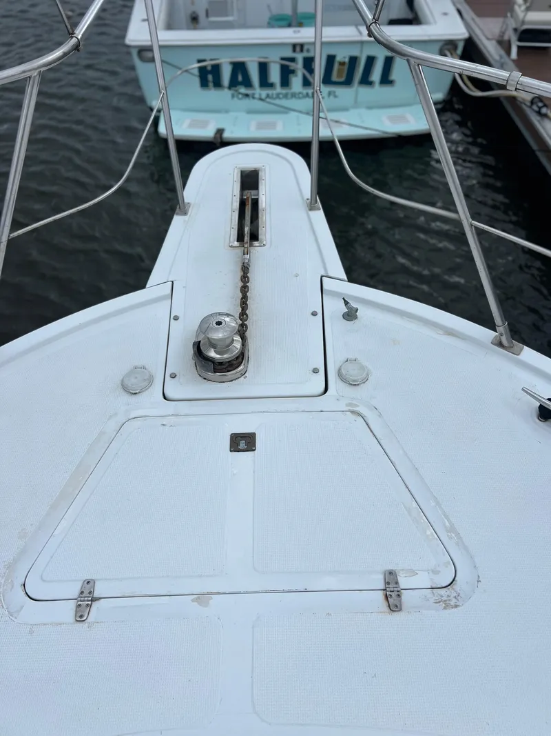 Slide: The Image of 1998 Hyatt 51 Aft Cabin Motor Yacht bow with anchor chain, docked near another boat. - 24