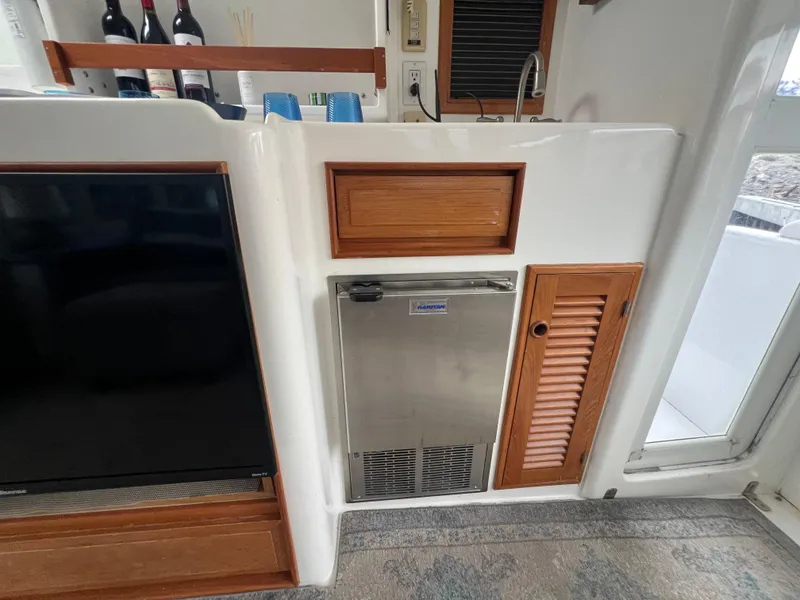 Slide: The Image of 1998 Hyatt 51 Aft Cabin Motor Yacht interior with fridge, cabinets, and TV. - 32