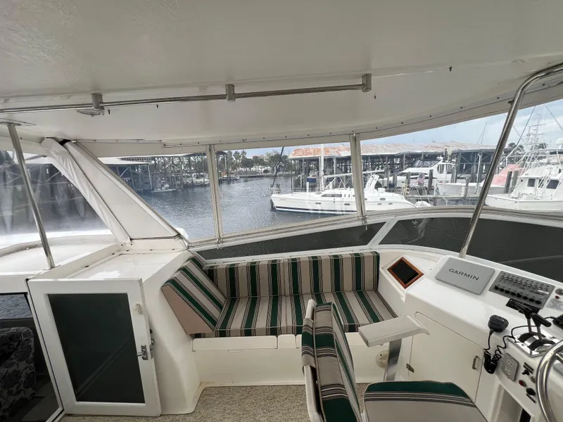 Slide: The Image of 1998 Hyatt 51 Aft Cabin Motor Yacht interior with striped seating and marina view. - 39