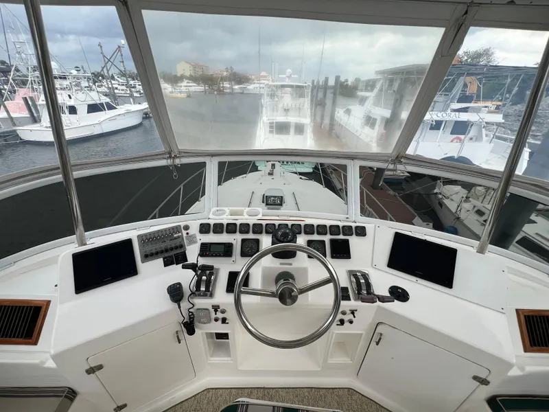 Slide: The Image of 1998 Hyatt 51 Aft Cabin Motor Yacht helm with navigation controls and marina view. - 43