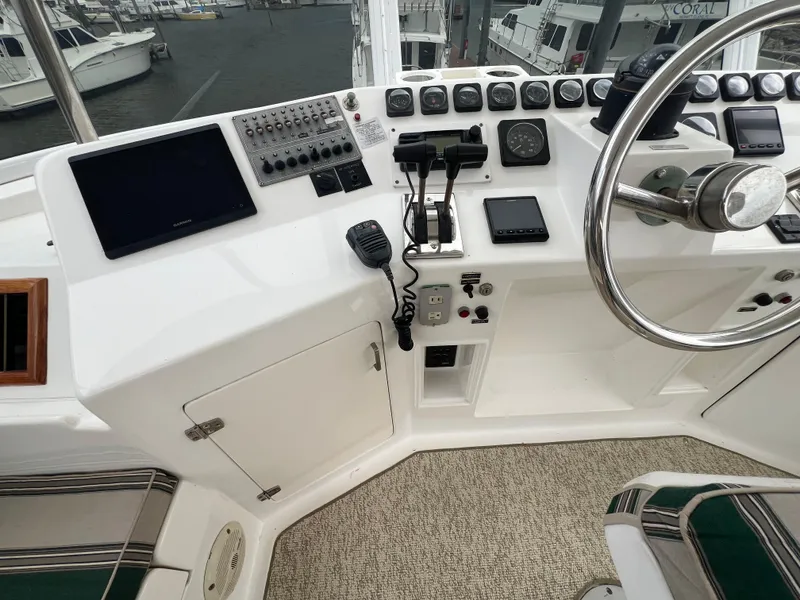 Slide: The Image of 1998 Hyatt 51 Aft Cabin Motor Yacht helm with navigation controls and steering wheel. - 45