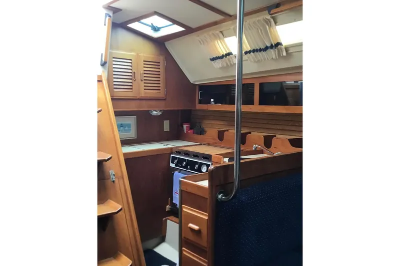 Slide: The Image of Interior of 1986 O'Day 40 sailboat with wooden cabinetry and compact kitchen area. - 11