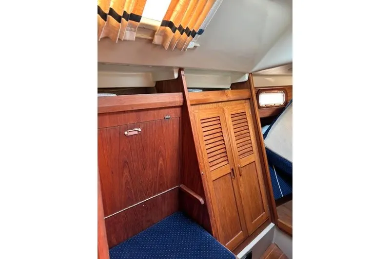 Slide: The Image of Interior of 1986 O'Day 40 sailboat with wooden cabinetry and blue upholstery. - 13