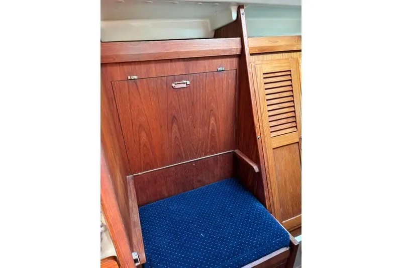 Slide: The Image of Interior of 1986 O'Day 40 sailboat with wooden cabinetry and blue cushioned seat. - 14