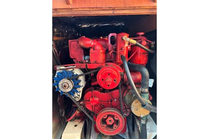 Slide: The Image of Red engine of a 1986 O'Day 40 sailboat, featuring belts and hoses. - 15