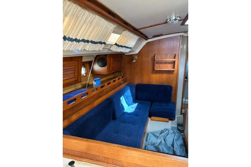 Slide: The Image of Interior of a 1986 O'Day 40 sailboat with blue seating and wooden accents. - 16