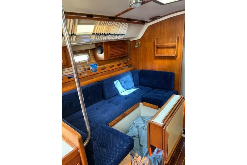 Slide: The Image of Interior of 1986 O'Day 40 sailboat with blue cushioned seating and wooden accents. - 17