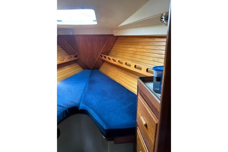 Slide: The Image of 1986 O'Day 40 sailboat cabin with blue cushions and wooden interior. - 22
