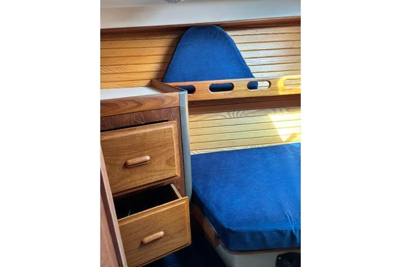 Slide: The Image of Interior of 1986 O'Day 40 sailboat with wooden drawers and blue cushioned seating. - 23