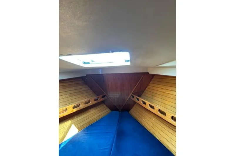 Slide: The Image of Interior cabin of 1986 O'Day 40 sailboat with wooden paneling and blue cushions. - 25