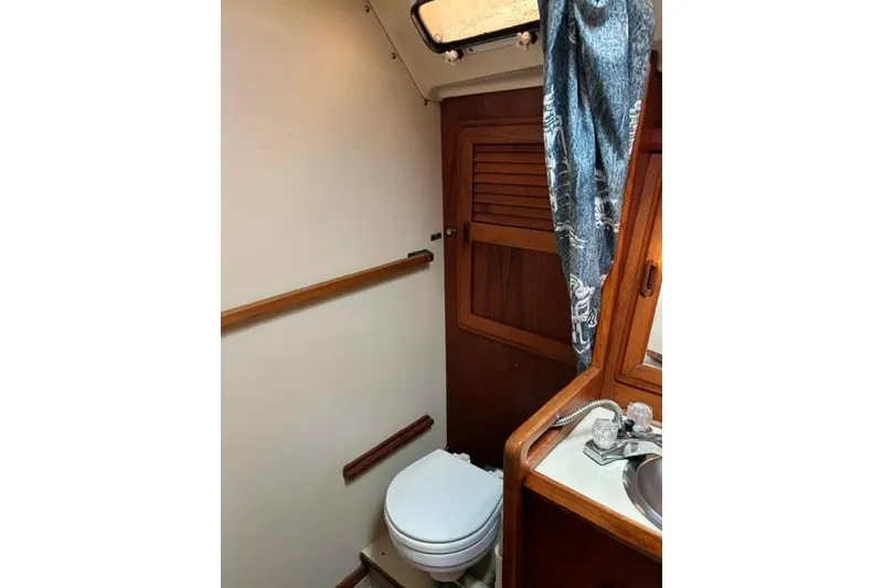 Slide: The Image of 1986 O'Day 40 yacht bathroom with toilet, sink, and wooden accents. - 26