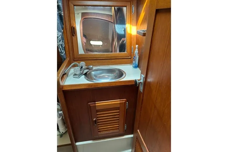 Slide: The Image of Wooden bathroom vanity with sink and mirror in a 1986 O'Day 40 sailboat. - 27