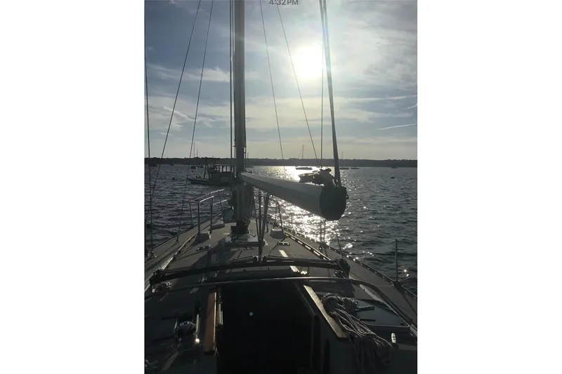Slide: The Image of 1986 O'Day 40 sailboat on water at sunset, with mast and calm sea. - 3