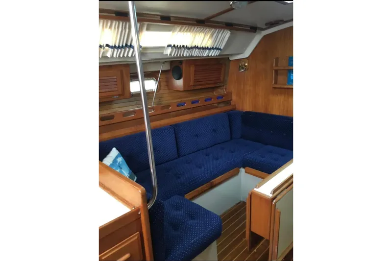 Slide: The Image of Interior of 1986 O'Day 40 sailboat with blue cushioned seating and wooden accents. - 4