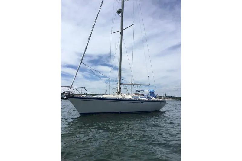 Slide: The Image of 1986 O'Day 40 sailboat on calm water under a partly cloudy sky. - 6