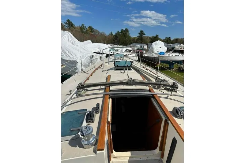Slide: The Image of 1986 O'Day 40 sailboat deck view with open hatch, surrounded by covered boats. - 8