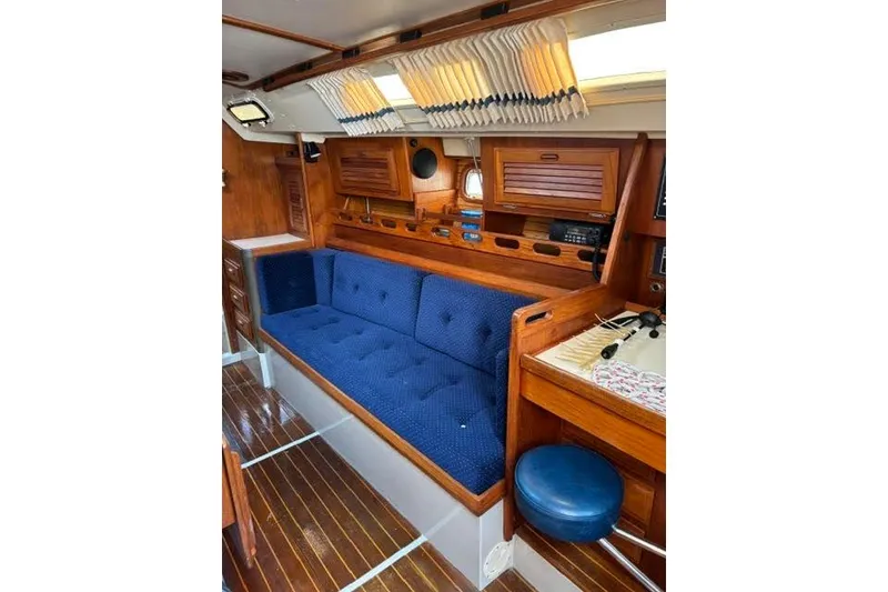 Slide: The Image of Interior of a 1986 O'Day 40 sailboat with blue cushioned seating and wooden cabinetry. - 9
