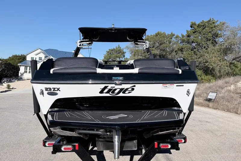 Slide: The Image of 2021 Tigé 23ZX boat on trailer, parked outdoors under clear blue sky. - 12