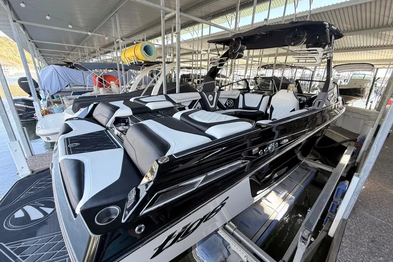 Slide: The Image of 2021 Tigé 23ZX boat docked in marina, featuring sleek black and white design. - 15