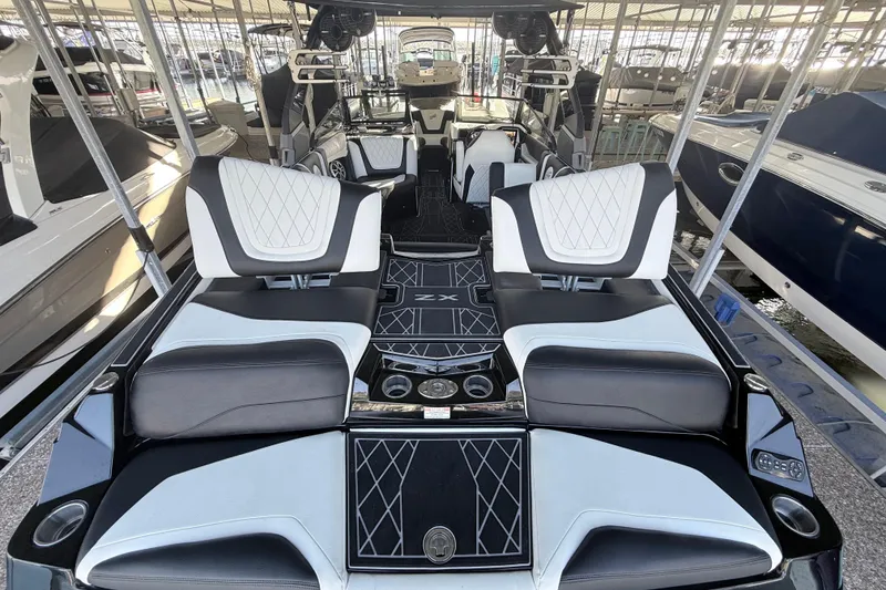 Slide: The Image of 2021 Tigé 23ZX boat interior with luxurious seating and modern design in a marina. - 16