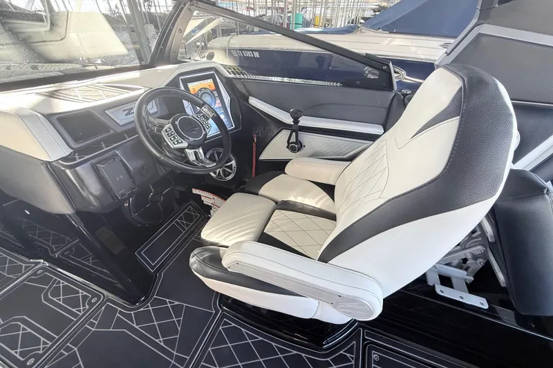 Slide: The Image of 2021 Tigé 23ZX boat dashboard with touchscreen controls and steering wheel. - 23