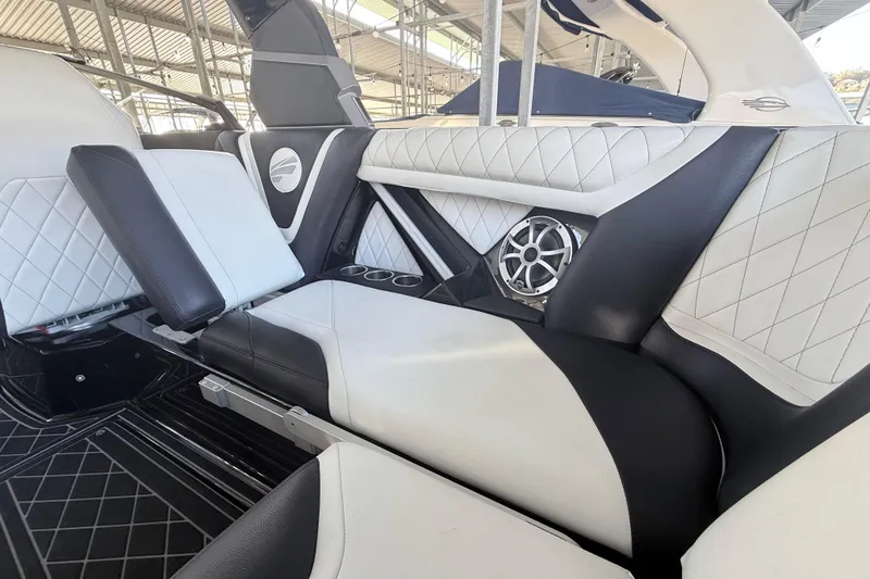 Slide: The Image of 2021 Tigé 23ZX boat interior with stylish black and white seating, cup holders, and water view. - 25