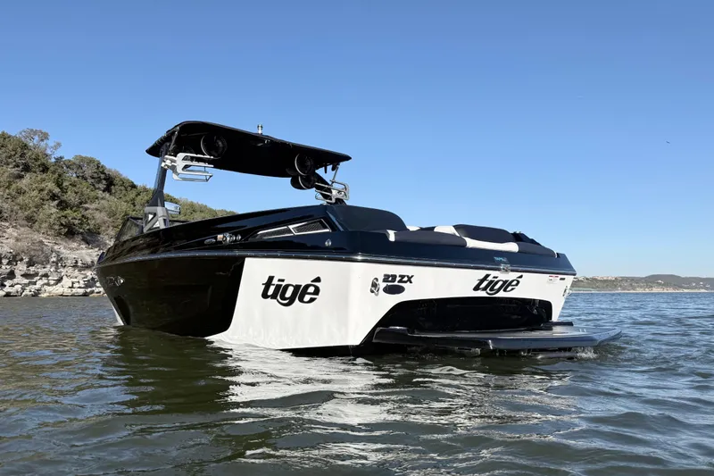 Slide: The Image of 2021 Tigé 23ZX boat on calm water under clear blue sky. - 4