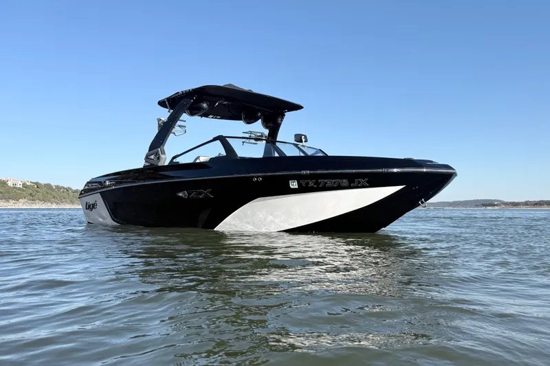 Slide: The Image of 2021 Tigé 23ZX boat on calm water with scenic rocky shoreline. - 8