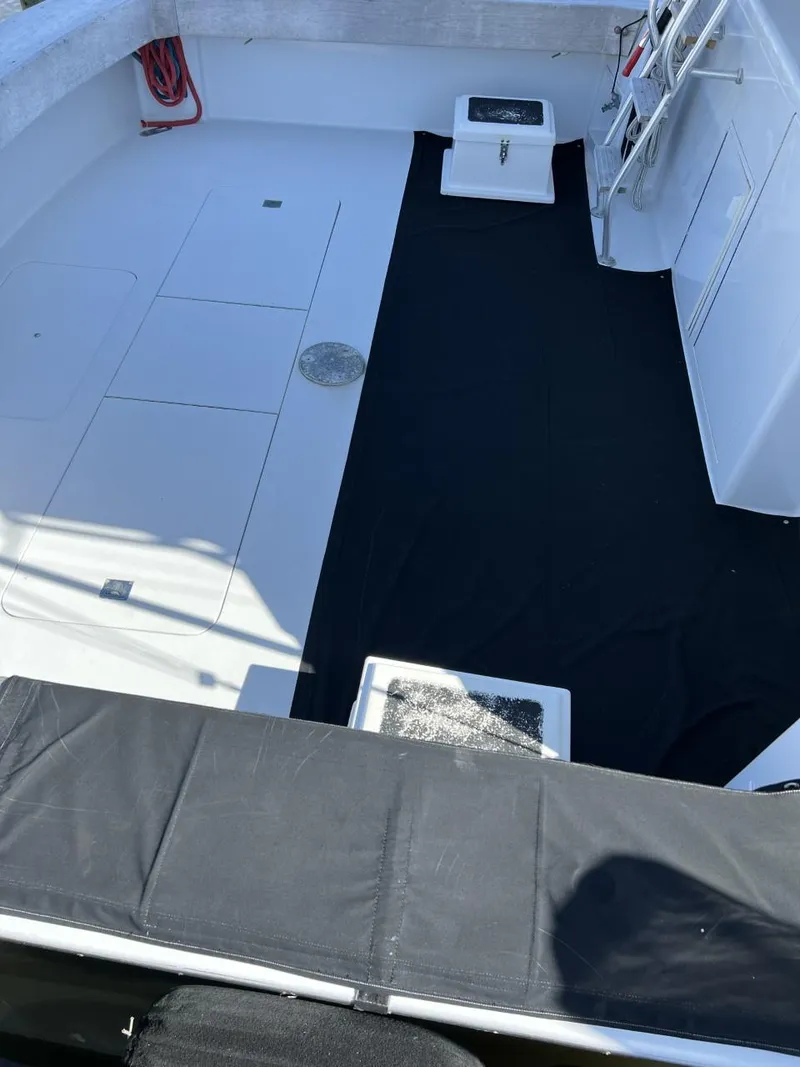 Slide: The Image of 1991 Viking Convertible boat deck with black mat and storage compartments. - 11