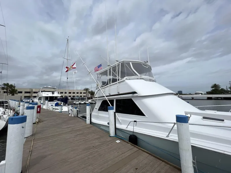 Slide: The Image of 1991 Viking Convertible yacht docked at marina under cloudy sky. - 2