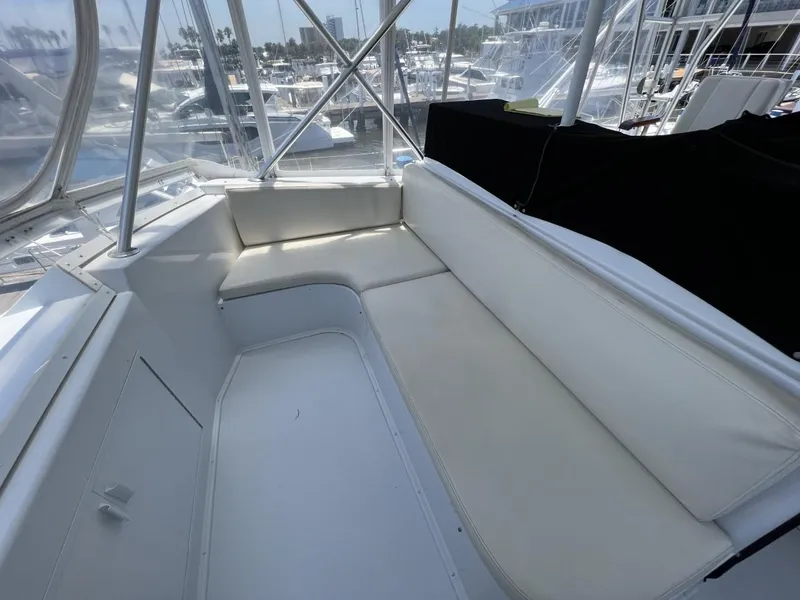 Slide: The Image of 1991 Viking Convertible yacht interior with white cushioned seating and marina view. - 20