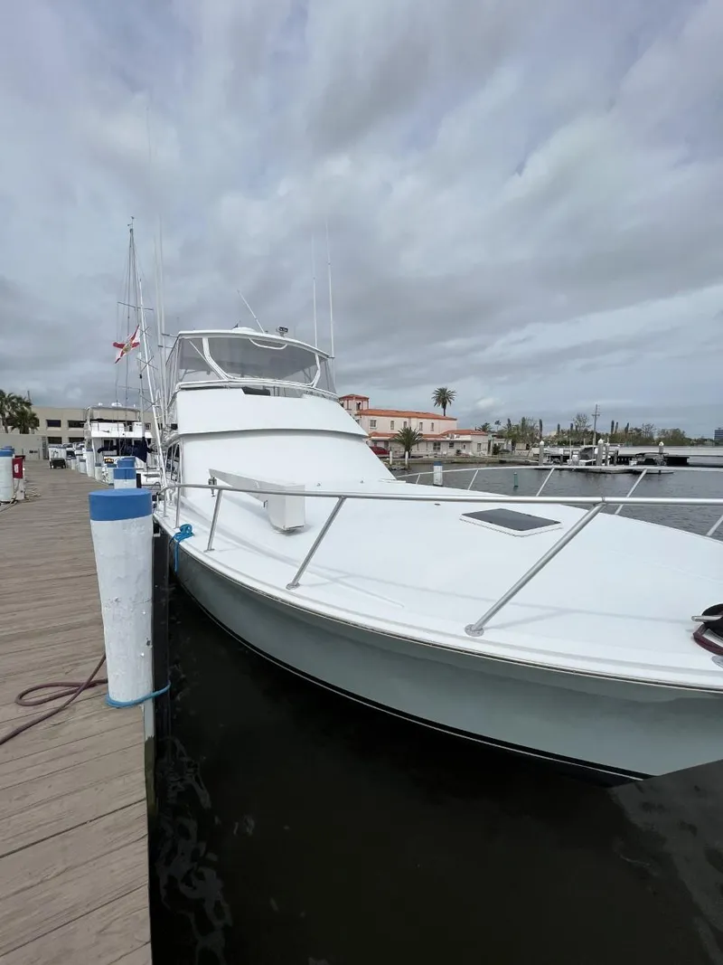 Slide: The Image of 1991 Viking Convertible yacht docked at a marina under cloudy skies. - 3