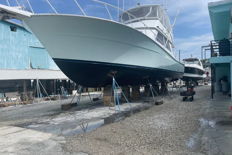 Slide: The Image of 1991 Viking Convertible yacht on stands in a boatyard, blue sky background. - 35