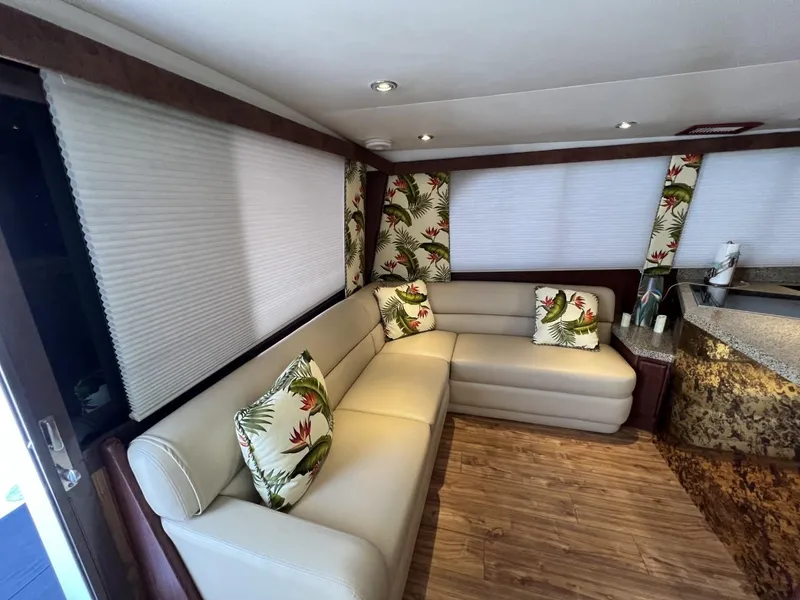 Slide: The Image of Luxurious 1991 Viking Convertible yacht interior with beige leather seating and tropical-themed cushions. - 38