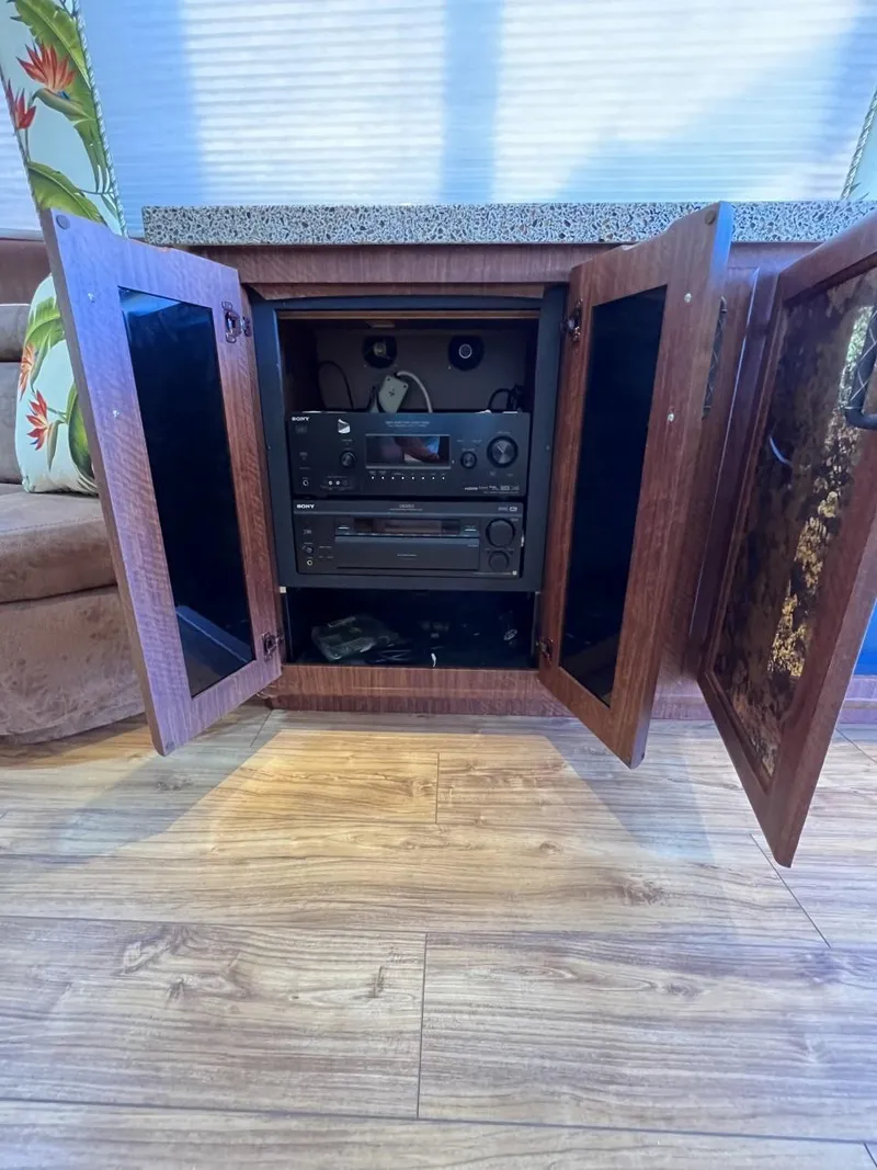 Slide: The Image of Wooden cabinet with open doors revealing audio equipment inside, on a 1991 Viking Convertible. - 42