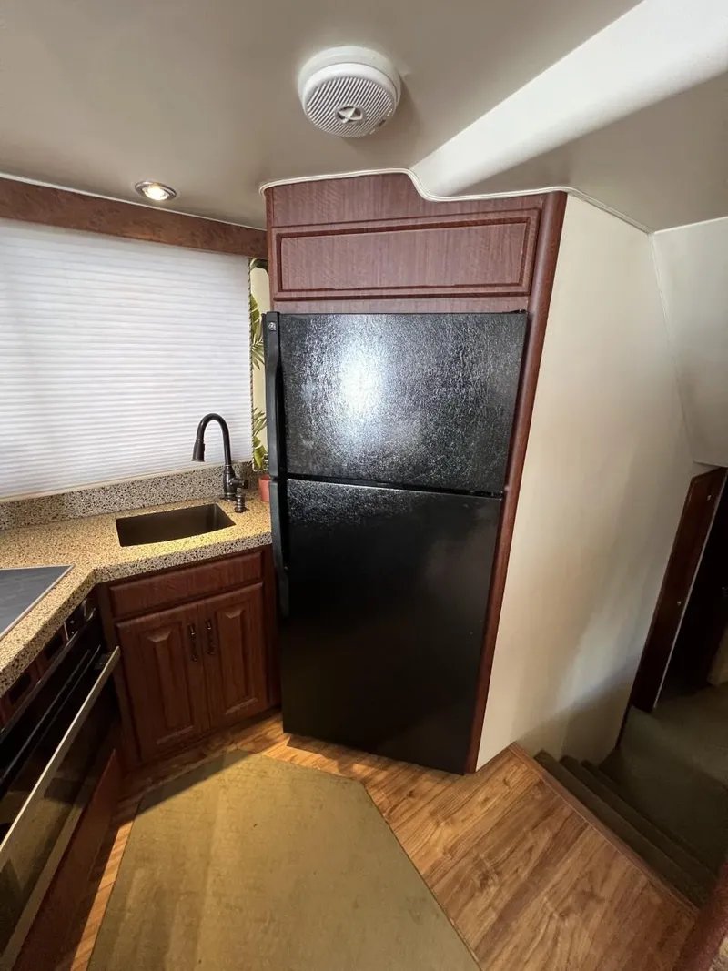 Slide: The Image of 1991 Viking Convertible kitchen with black fridge, wood cabinets, and modern sink. - 45