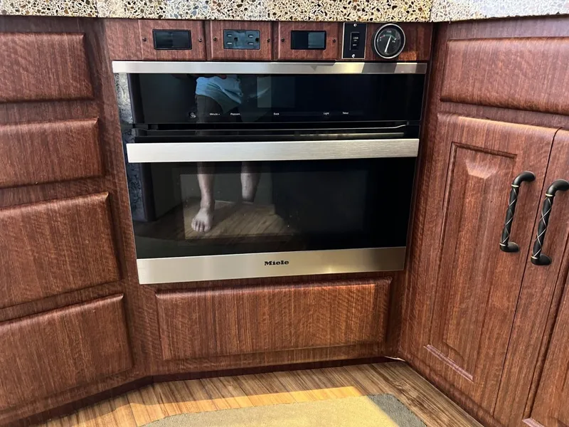 Slide: The Image of Modern kitchen with Miele oven, wooden cabinets, and granite countertop in a 1991 Viking Convertible. - 46