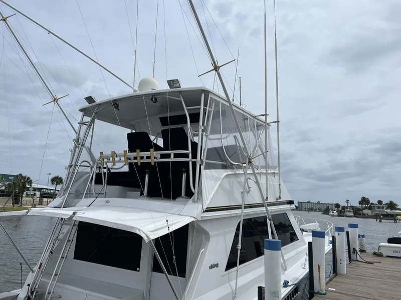 Slide: The Image of 1991 Viking Convertible yacht docked at marina under cloudy sky. - 5