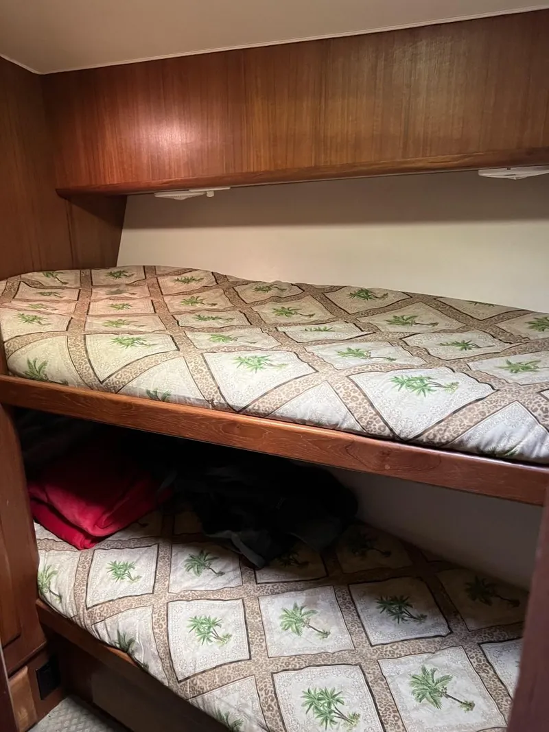 Slide: The Image of 1991 Viking Convertible boat interior with wooden bunk beds and patterned bedding. - 50
