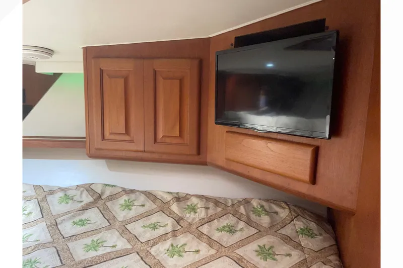 Slide: The Image of 1991 Viking Convertible interior with TV, wooden cabinets, and patterned bedding. - 58