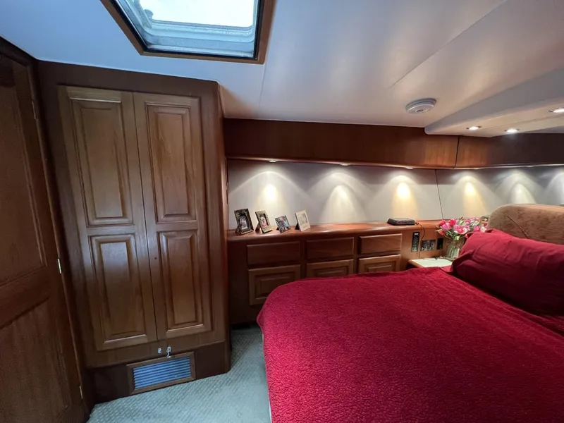 Slide: The Image of Luxurious 1991 Viking Convertible yacht bedroom with red bedding and wooden cabinetry. - 63