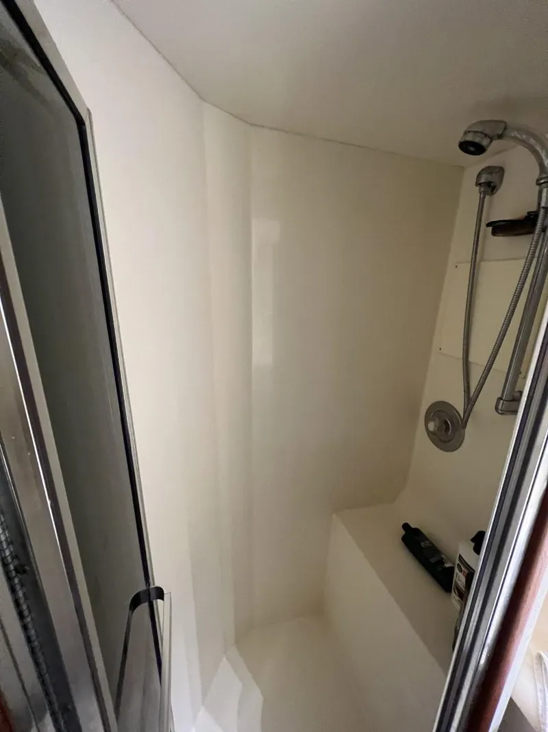 Slide: The Image of Shower area inside a 1991 Viking Convertible boat, featuring a handheld showerhead. - 69